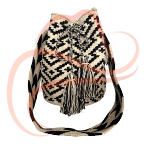 Mochila Wayúu vista desde el frente, con un diseño geométrico en colores beige, negro y detalles en café. Lleva pompones decorativos colgando y un asa larga tejida a juego.