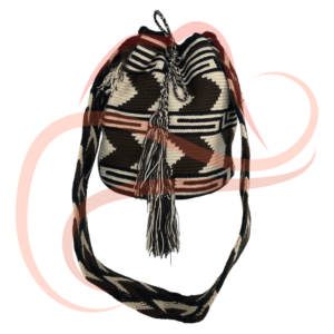 Mochila Wayúu elaborada con patrones geométricos en blanco y negro. El diseño presenta figuras triangulares y zigzag que aportan contraste, acompañado de borlas y una correa tejida en colores similares.